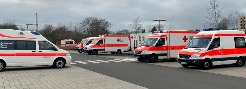 DRK Einsatzfahrzeuge stehen auf einem Parkplatz.