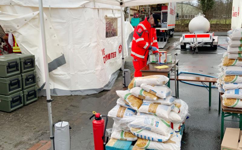 Zelt von den Johannitern. Ein Mann sortiert Hilfsmittel.